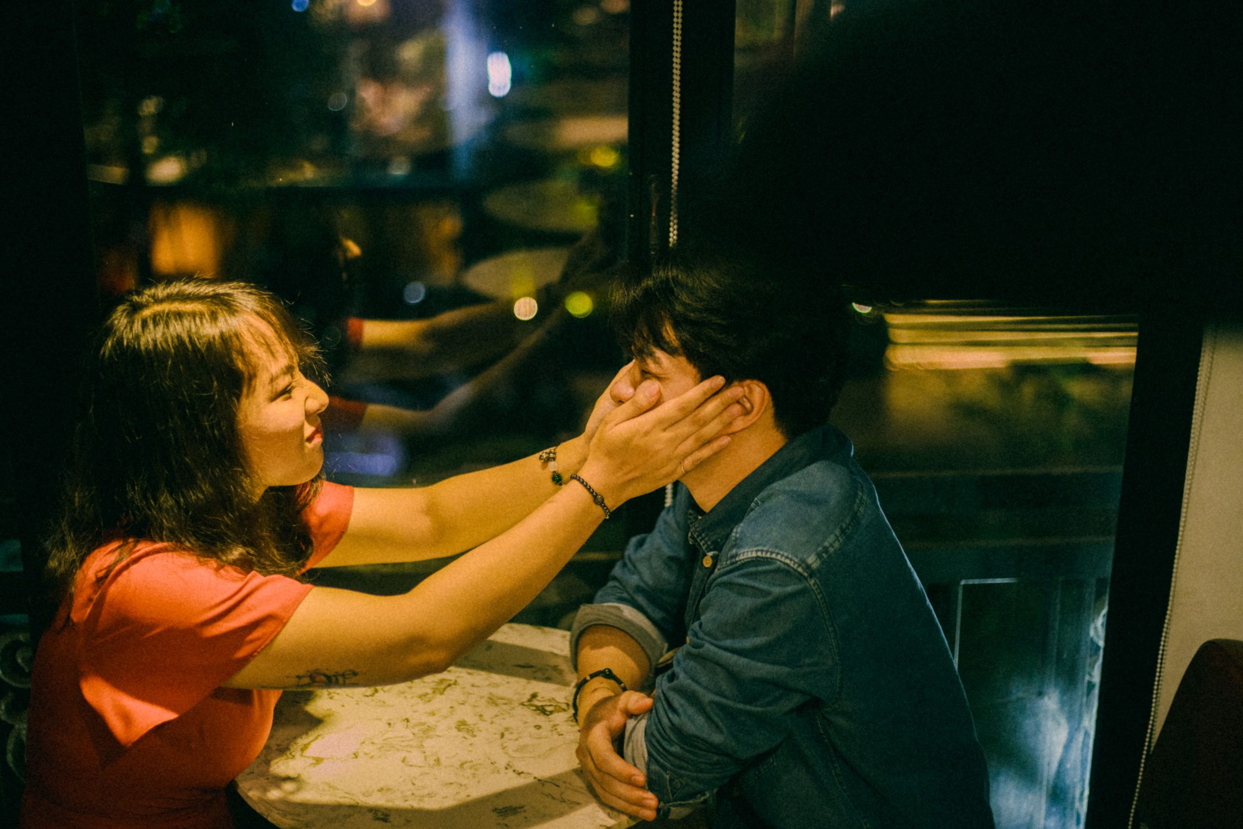 Couple au café s'échangeant une caresse affectueuse