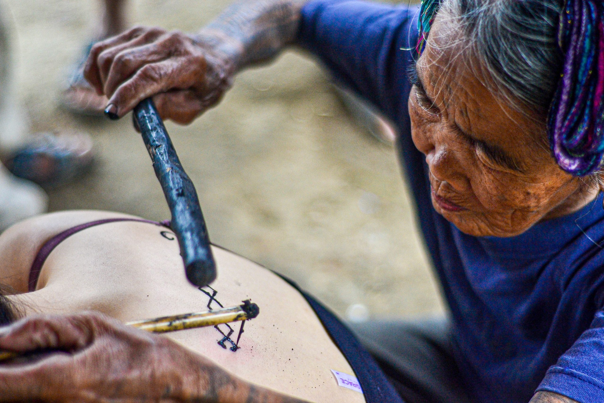 Femme âgée tatouant dans la tradition Kalinga