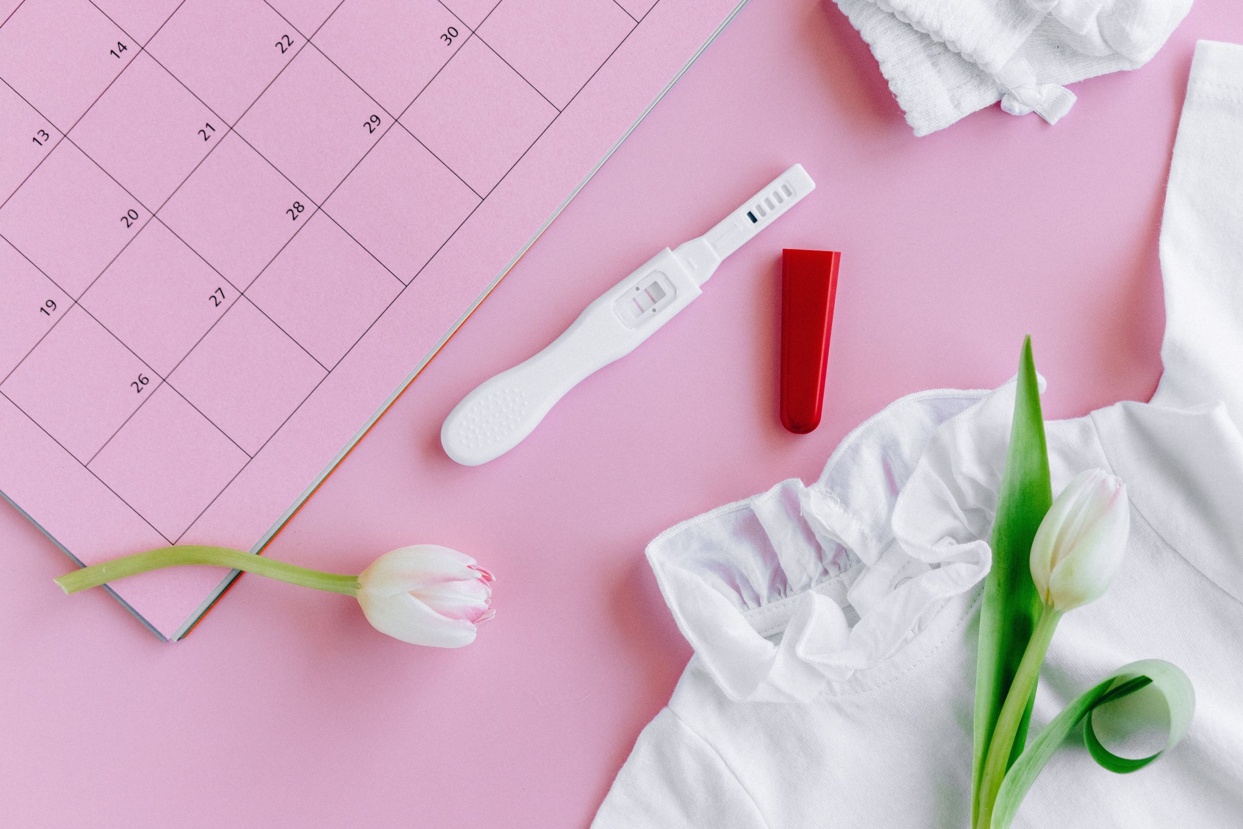 Test de grossesse avec tulipes sur calendrier rose