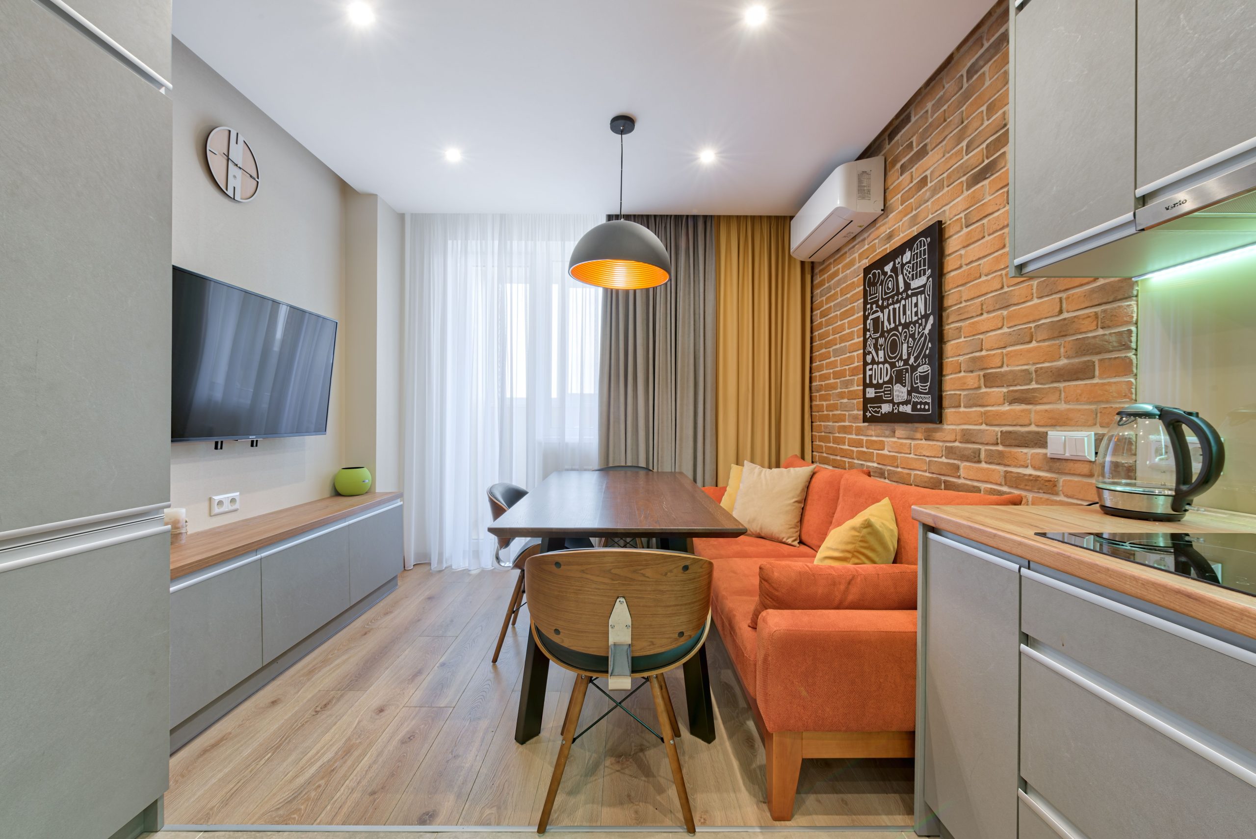 Salon stylé avec canapé orange et mur brique