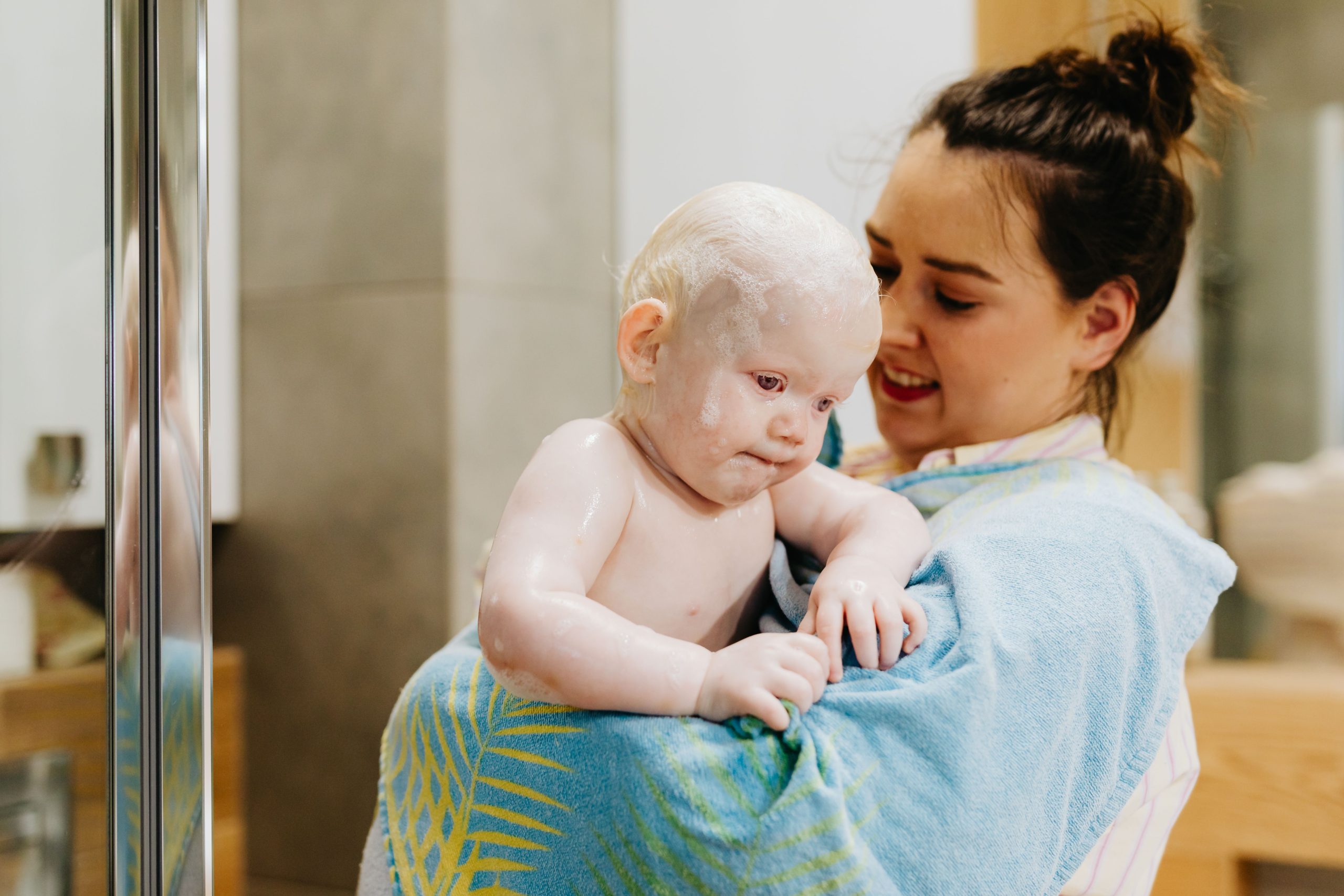 Mère enveloppe tendrement son bébé après le bain