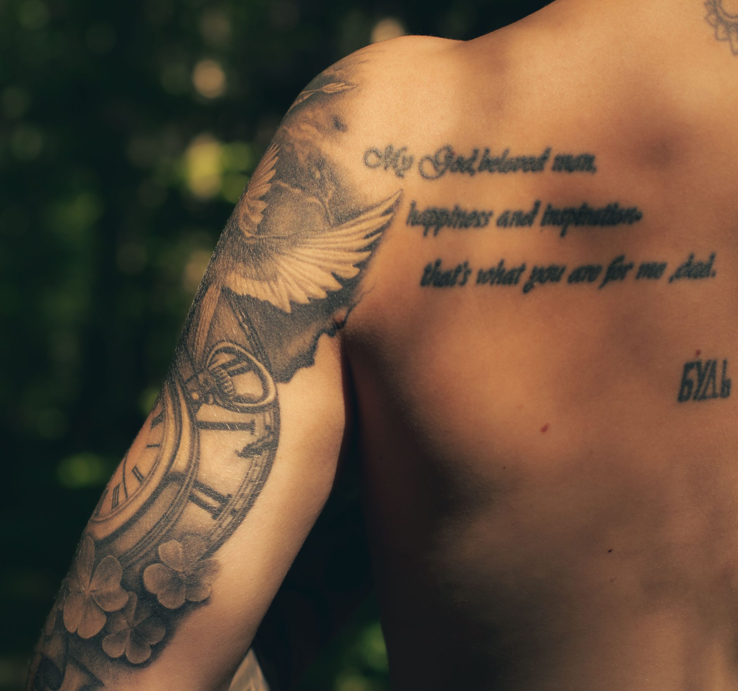 Bras tatoué avec motifs artistiques et texte