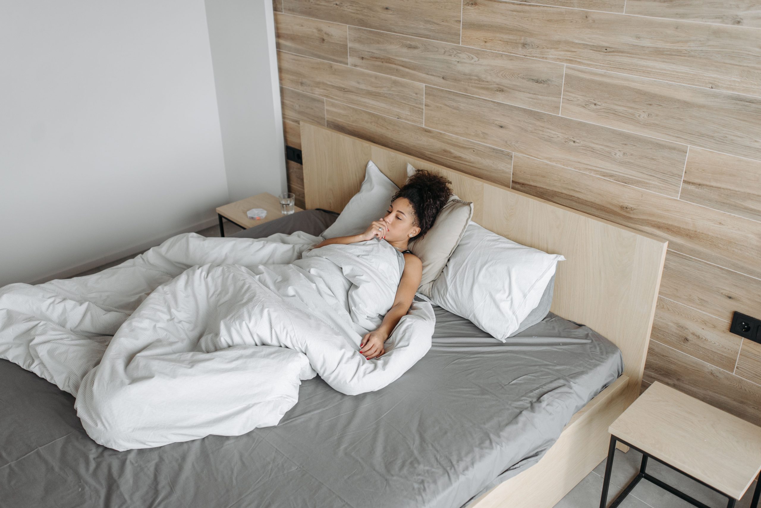 Femme allongée au lit sous couverture malade