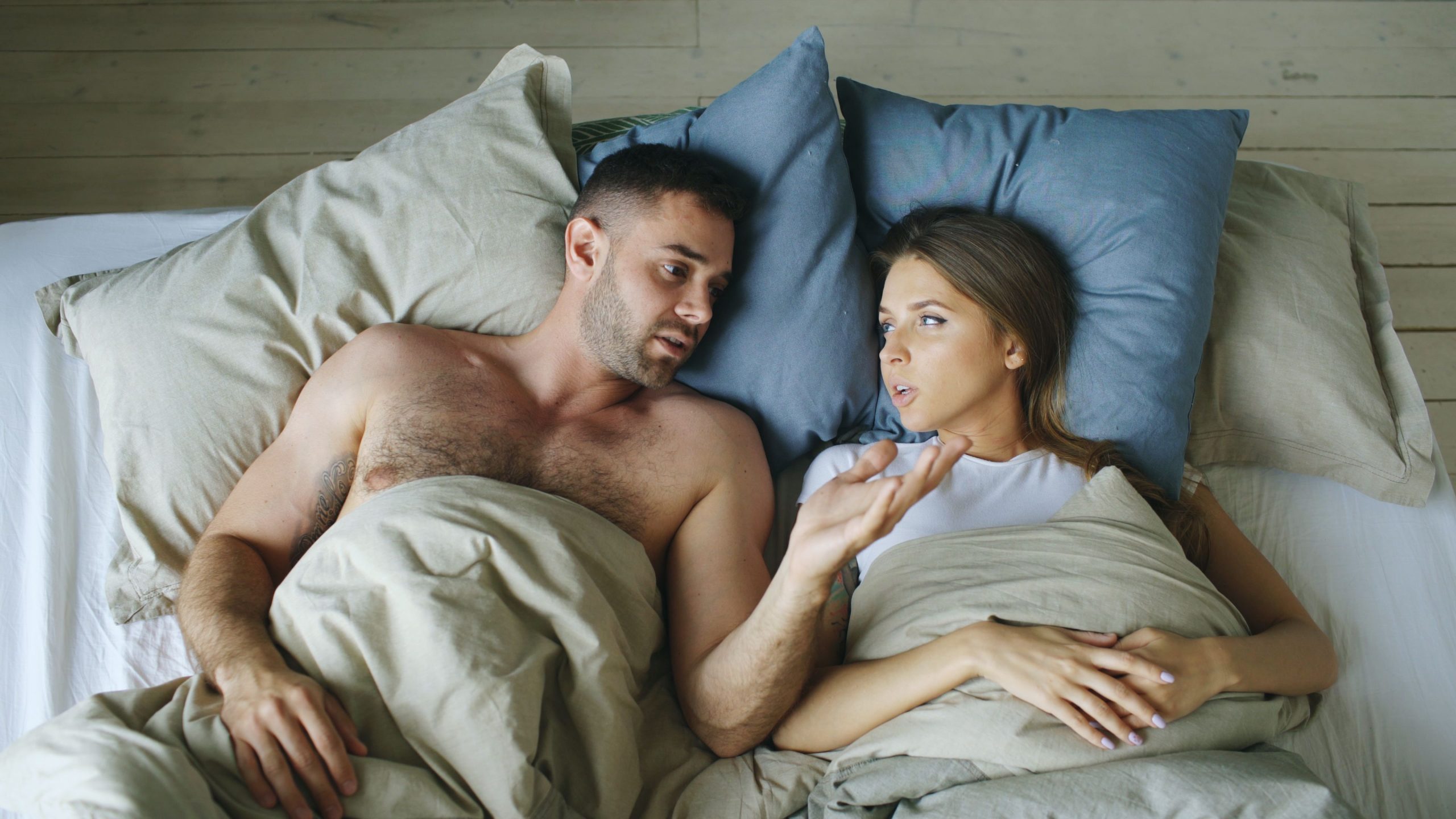 Couple allongé au lit en conversation intime