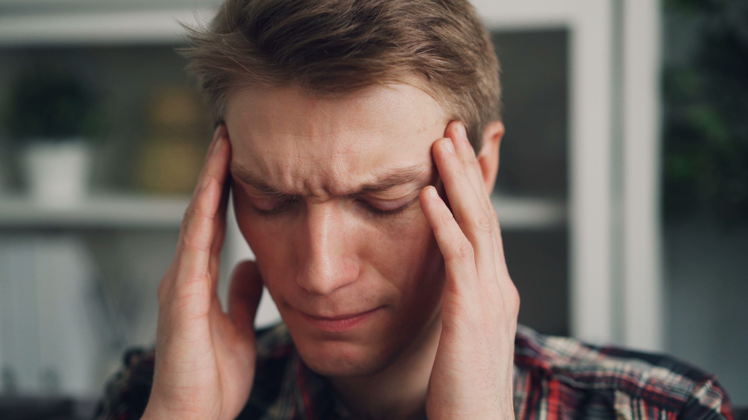 Homme stressé se massant les tempes fermant les yeux