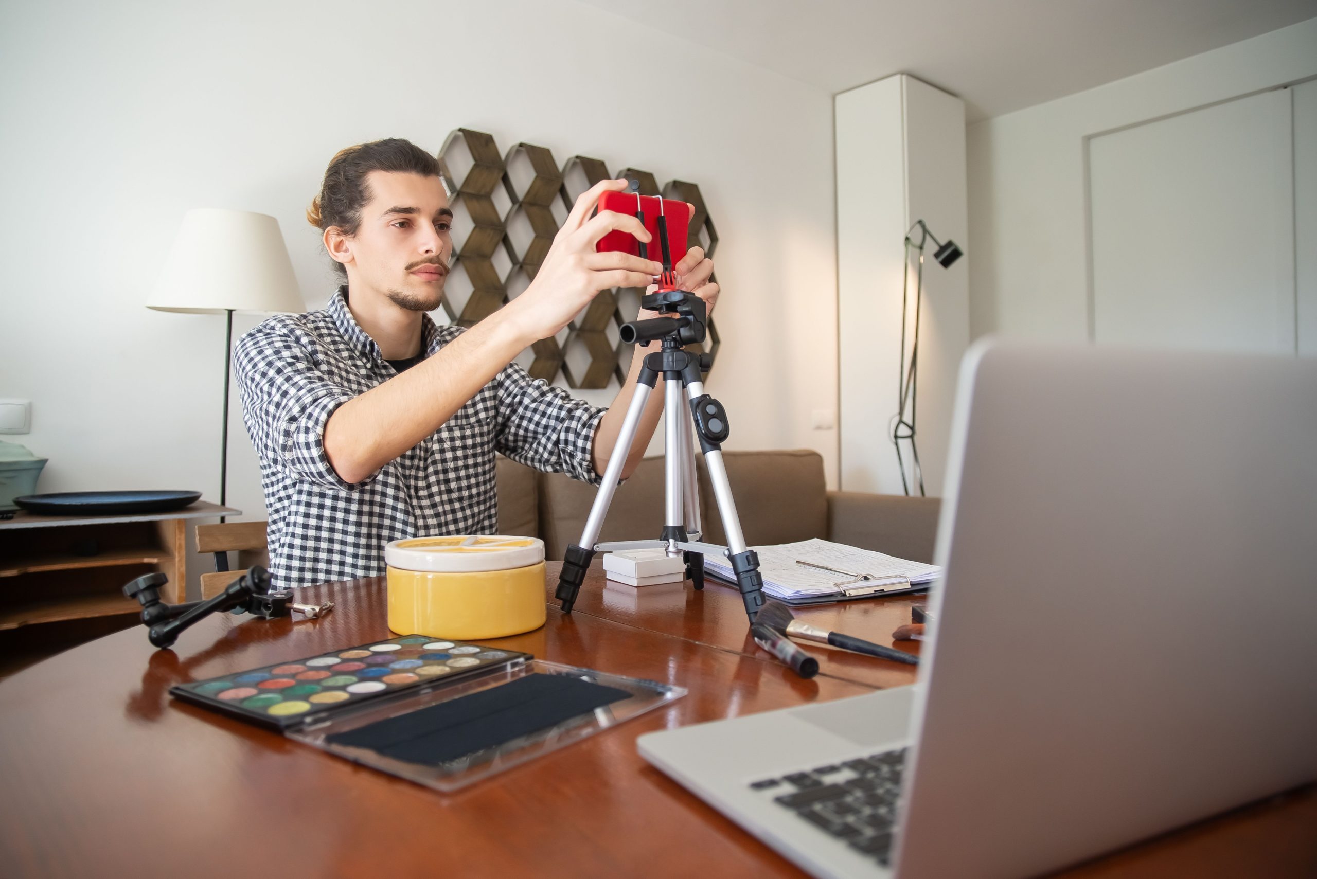Vlogger ajuste sa caméra sur trépied à domicile