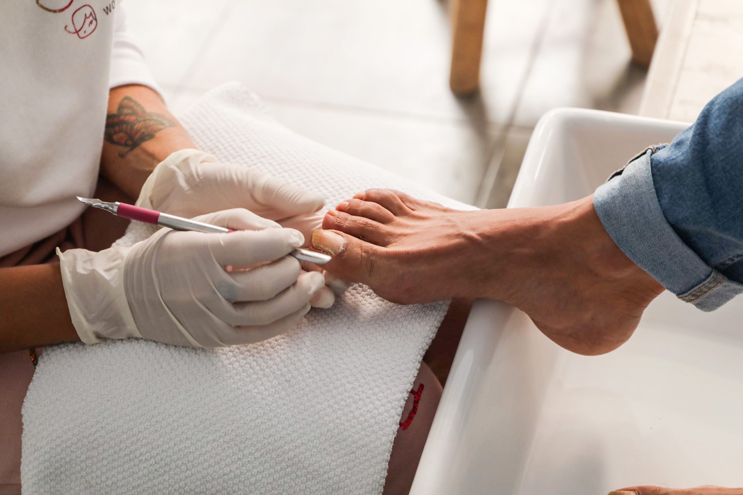 Mains gantées effectuant soin pédicure professionnel