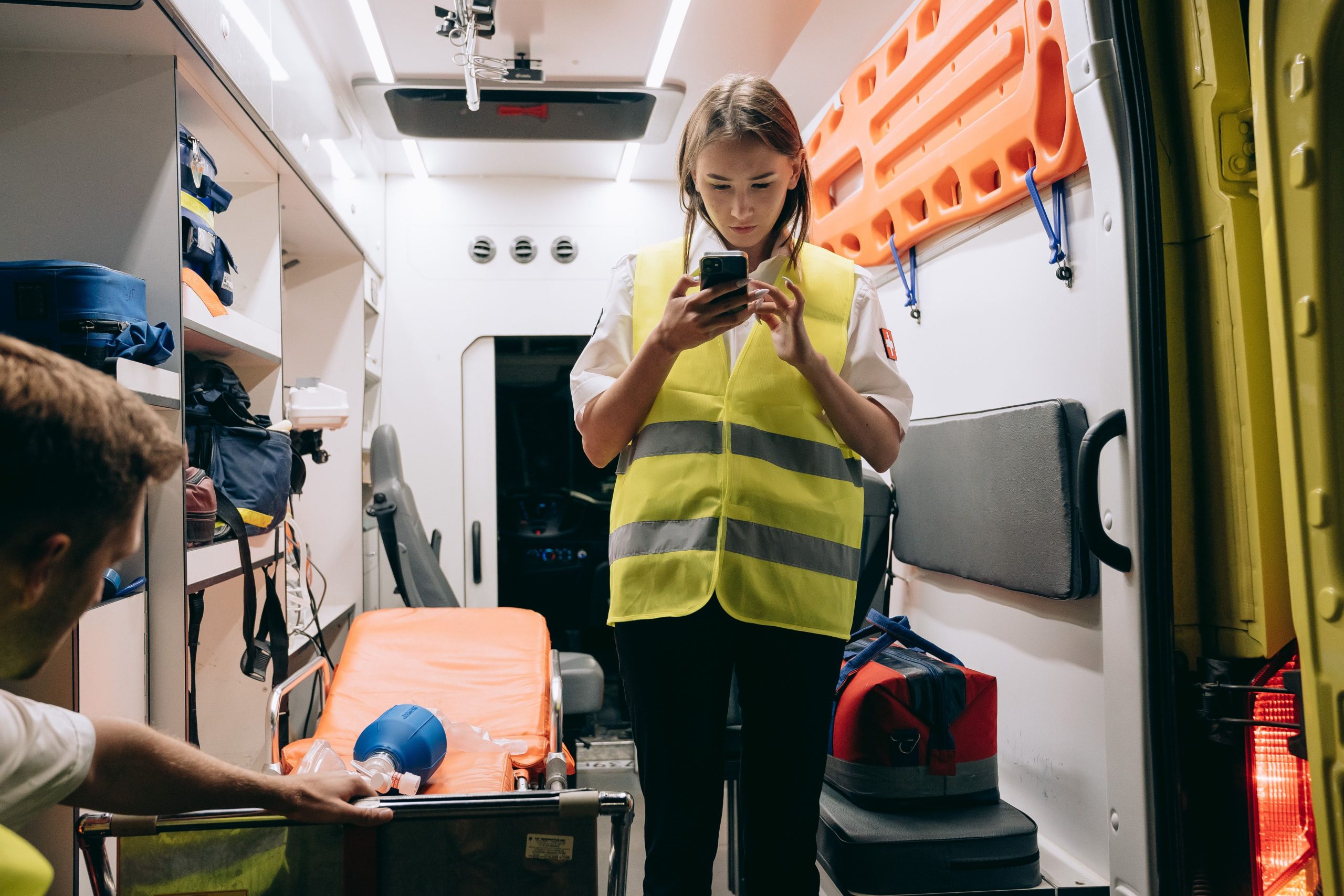Paramédicale utilisant un smartphone dans ambulance