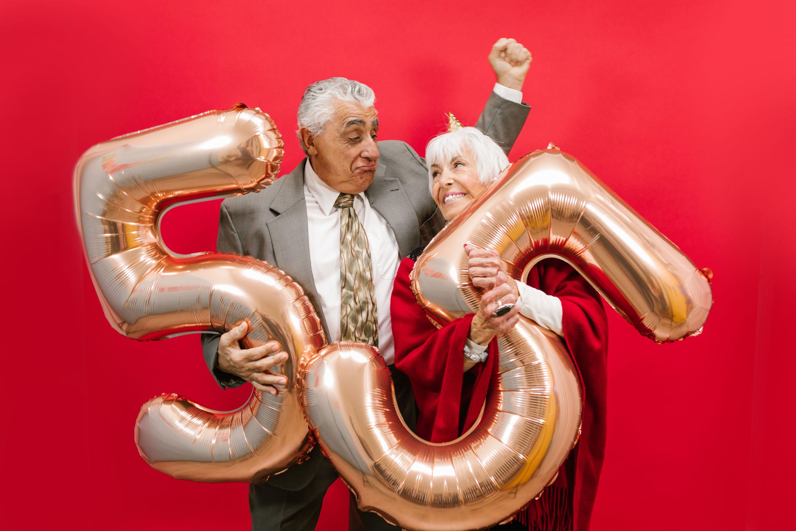 Couple heureux celebrant avec ballons or et confettis