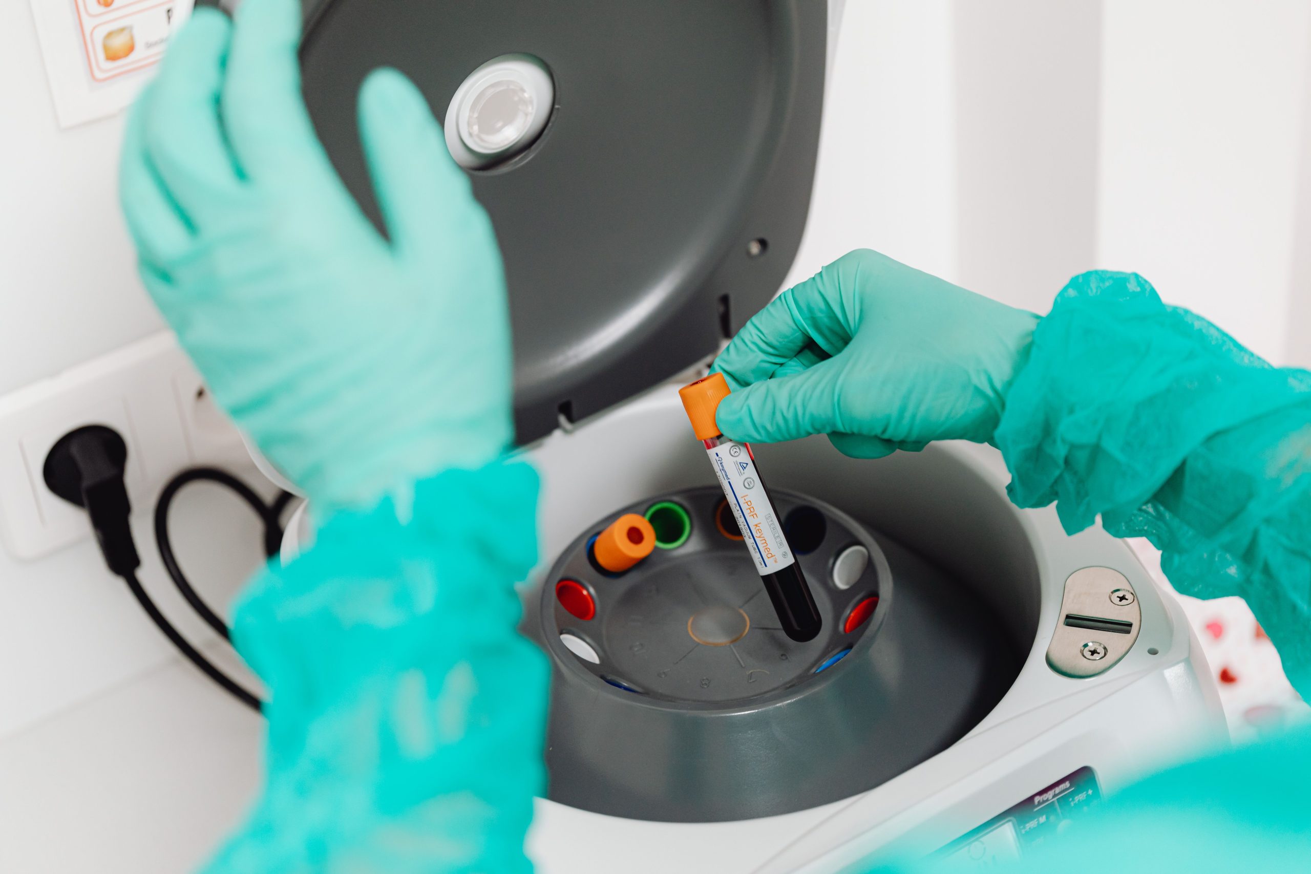 Technicien laboratoire utilisant centrifugeuse analyse