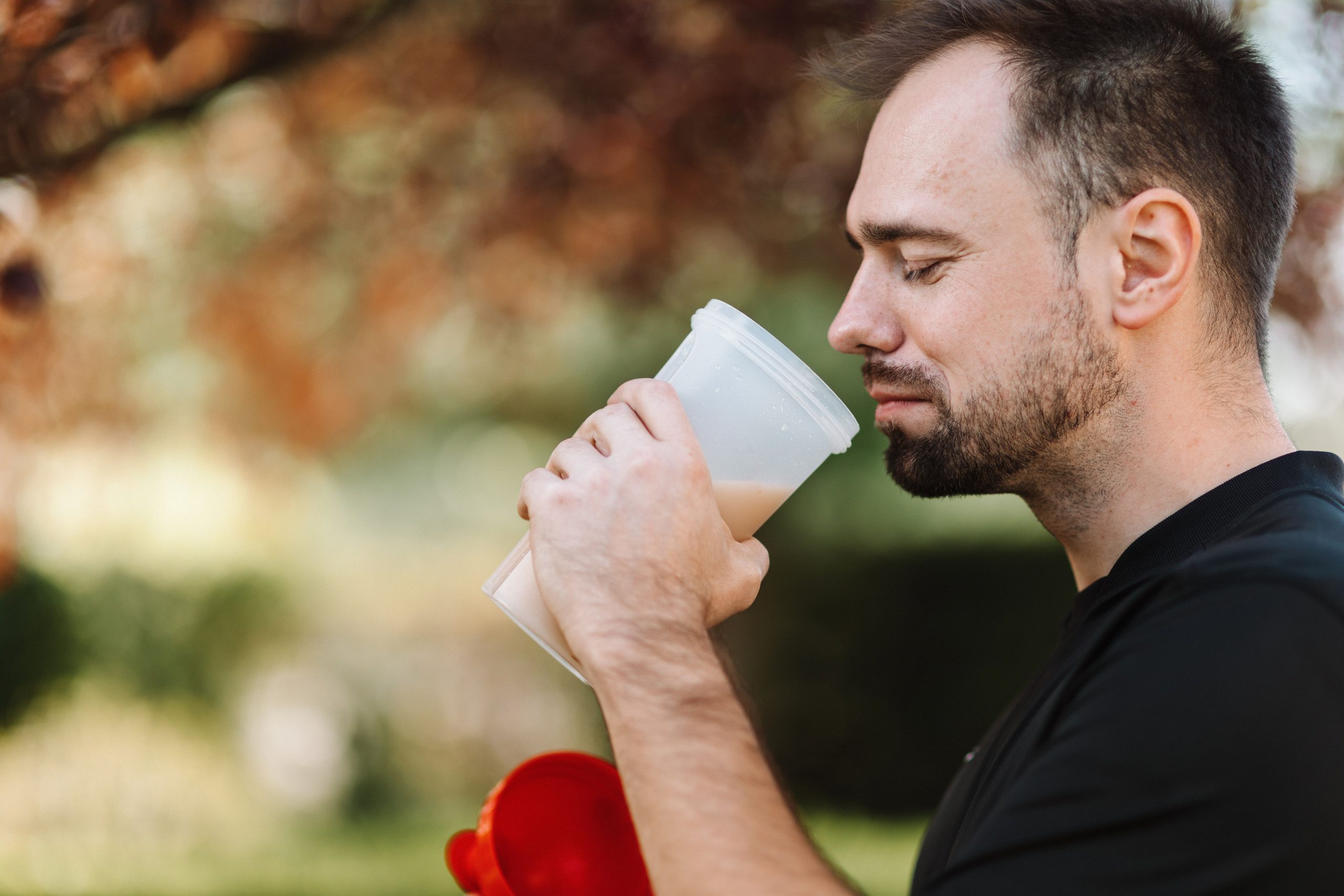 Homme savourant un shaker de protéine en plein air
