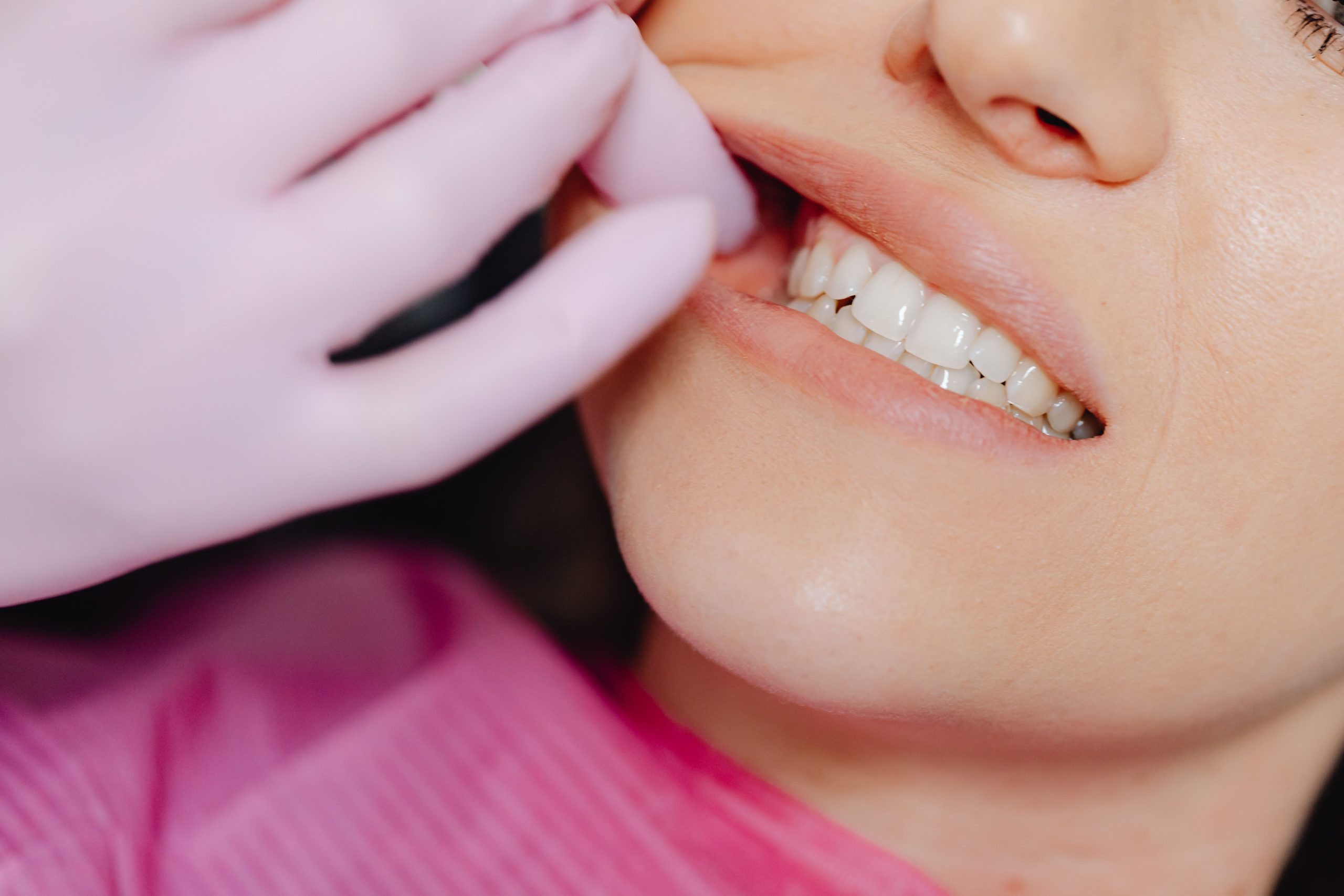 Main gantée examinant les dents d'un patient